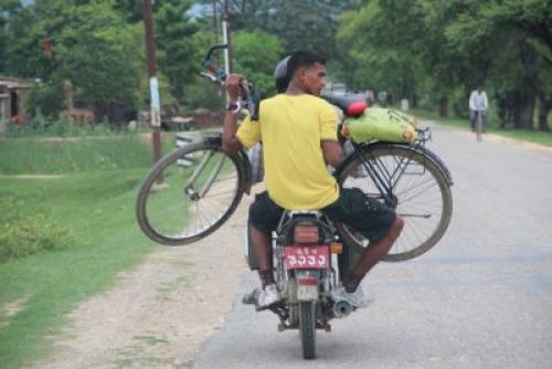 DOUBLE TROUBLE  A man ferrying his bicycle in a motorbike near Kohalpur in Banke district  PIC