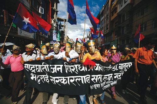 DOUBLE FACED: Members of UML affiliated Youth Association Nepal wear masks of PM Bhattarai during a protest rally at Bagbazaar on Monday and demand for his immediate resignation.