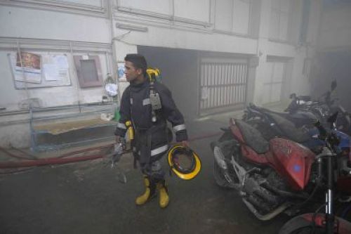 FIGHTING FIRE : A firefighter trying to douse flame at the basement of City Centre, a shopping mall, that caught on fire after a generator short-circuited on Wednesday afternoon.  PIC