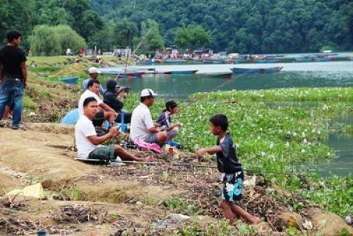 TONIGHT'S DINNER: Local of Pokhara enjoy fishing on an overcast Saturday afternoon.PIC