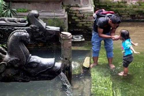 THIRSTY TODDLER: A father helps his daughter have a sip of water from a stone sprout in Patan Darbar Square on Saturday. PIC