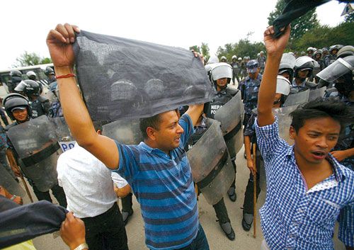 MEANWHILE.. : Activists of the UML-affiliated Youth Association Nepal wave black flags at Bhattarai at Tribhuvan International Airport on Wednesday demanding his immediate resignation.