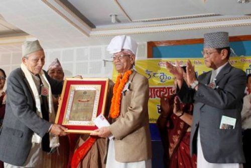 MIRROR IMAGE: Til Bikram Nembang (right), popularly known as Bairagi Kainla recieves the Ratna Shova Subhalaxmi Mundhum Award for his exceptional contribution to the field of Nepali literature in Lalitpur on Sunday. PIC