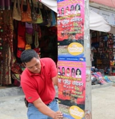 A member of All Nepal Hotel and Restaurant Workers Union pastes posters around Lakeside Pokhara on Sunday advertising the Union's fourth national conference.