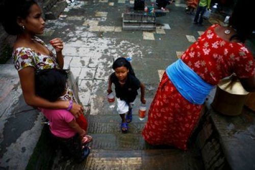 DAILY ROUTINE: A girl helps her mum to fetch water filling soda bottles from a public stone fountain in Lalitpur, on Tuesday.