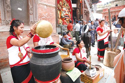 MAKE A TOAST: As part of World Tourism Day celebrations women show a curious passerby how to make traditional Newari alcohol at Kathmandu Darbar Square on Wednesday.