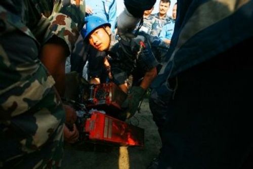 FOUND IT: Security personnel recover the plane's black box from the crash site.