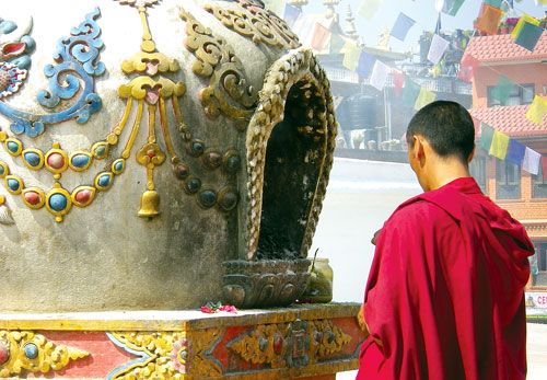 CALM IN CHAOS: A Buddhist monk finds peace while praying at Boudhanath Stupa some metres away from the swarming streets of Kathmandu.