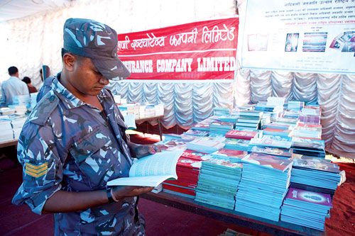 READING PATROL: A policeman glances through a book while on duty at the National Book Exhibition. The fair will be held until 13 October.