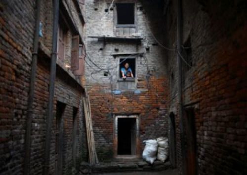 SNEAK PEEK: While getting things ready for Dasain at home, a woman takes a rest with her child to look out of their house in Bhaktapur on Monday.