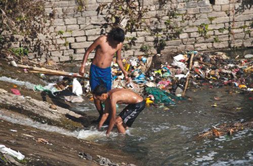 FISHY EXPECTATIONS: Despite the fact that the Bagmati River is highly polluted, these young boys try their best to catch fish using a net at Tilganga in Kathmandu.