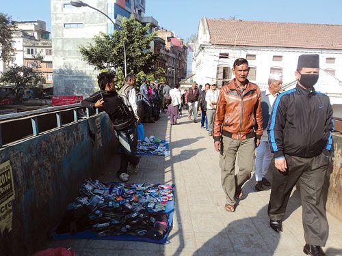 DOUBLE-USE: Street hawkers use the overhead bridge in Bhotahiti to display their goods on Tuesday morning. Many pedestrians jaywalk across the busy street instead of using the bridge.