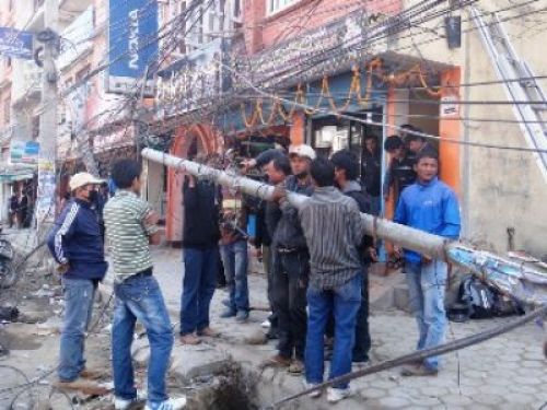 STRENGTH IN NUMBERS: Neighbours and passer-bys help to untangle the wires of the traffic pole before its relocation in the same street at Kumaripati road, on Tuesday afternoon.