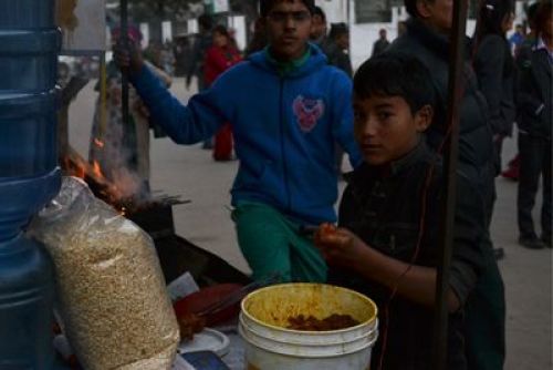 AFTER HOURS: A boy prepares barbeque for a customer at his uncle's street stall at New Baneswor on Tuesday evening.