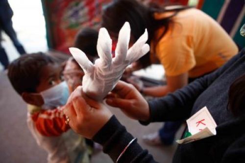 HELPING HANDS: Volunteers help local children in Teku put on masks and gloves as they get ready to clean the Bagmati on Wednesday afternoon to mark International Volunteer Day.