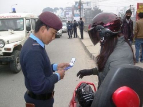 JUST CHECKING: A policeman inspects a woman's driving licence at the Bagmati bridge in Thapathali on early Tuesday morning.
