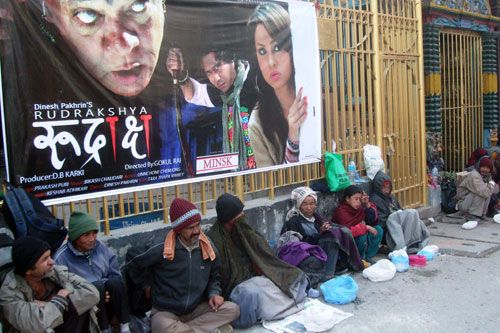 REAL LIFE DRAMA: Banners promoting the drama film Rudraskshya are displayed near Ganesh temple in Kamaladi. Down the poster, beggars wait for some food from well-wishers.