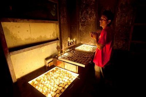 LIVING ON A PRAYER: A man repeats his prayers and lights oil lamps at Swayambhunath, on Friday evening.