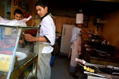 DEEP FRY: The kitchen staff of a restaurant near Naxal prepare dishes for customers on Sunday afternoon. Customers are gradaully returning now that the road in front of the restaurant has been black-topped.