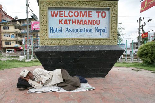 WAKE ME UP WHEN WE GET THERE: A man decides to take a nap at the Hotel Association of Nepal's welcome sign at Maitighar Mandala on Monday. There is deep disllusionment about the prolonged political deadlock that is preventing the formation of a new government three months after elections.