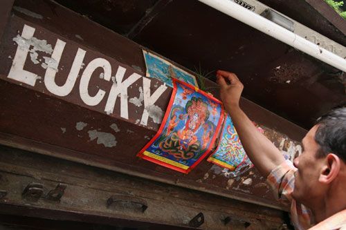 LUCKY GUY: A shopkeeper in Kathmandu puts up a poster of a nag for protection and good luck on Wednesday, which is Nag Panchami.