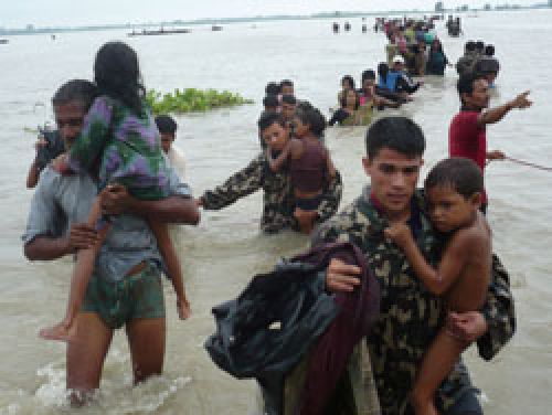 HOLD TIGHT: Soldiers and the locals wade through the flood, leaving their homes and land far behind.
