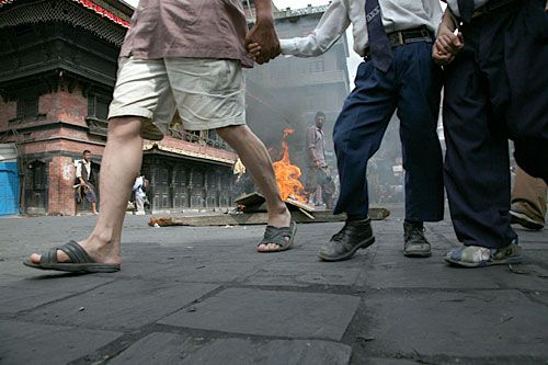 BUFFALO RIOT: A school boy being taken to school past a burning barricade in Asan on Monday put up by protestors who were not satisfied with the government's climbdown on cutting the budget for buffalo sacrifices at Indra Jatra and Dasain.