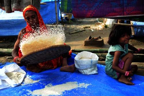WINNOWING: Wokilan Bibi, 45, winnows rice to feed her family at a temporary shelter in Jhumka, Sunsari. Flood victims are allocated 12.5 kg of rice per person each month at government-run relief camps where 35,000 refugees have been staying since September 18.