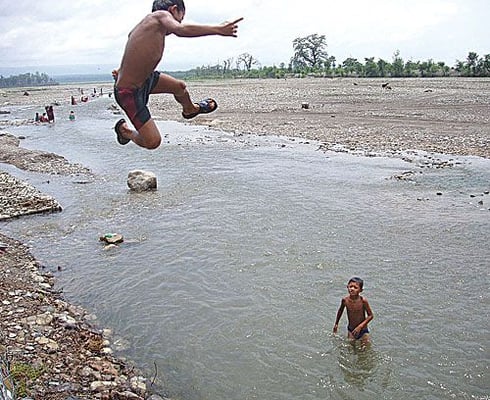 YAHOO: A boy jumps into the water of the Lothar river last week in Chitwan. A flash flood on this river in October 2000 killed hundreds of people.