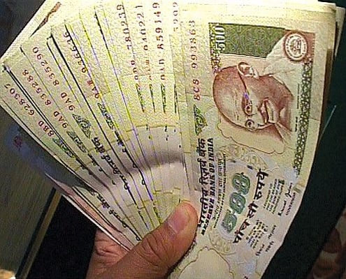 FUNNY MONEY: A policeman in Birganj last week holds a wad of Indian 500 rupee notes from a consignment of counterfeit currency seized at the border.