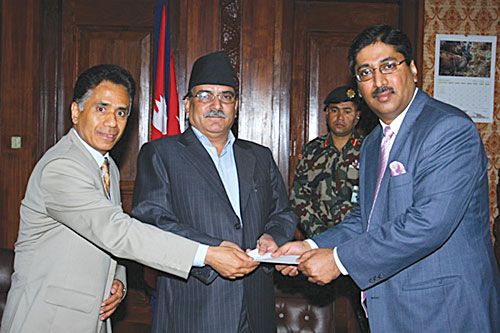 CHEQUE THAT: Prime Minister Pushpa Kamal Dahal receives a cheque for Rs 1 million on Sunday at Singha Darbar from Kamran Bakr (right), managing director of Unilever for the rehabilitation of those displaced by the Kosi. Unilever director Ravi Bhakta Shrestha is at left.