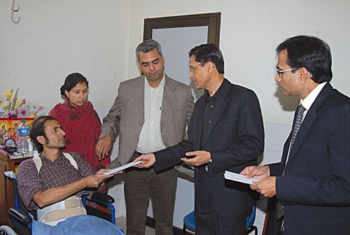 HELPING HAND: Economic journalist Gajendra Budathoki receives a cheque for Rs 50,000 from Sujit Mundul (right), CEO of Standard Chartered Bank Nepal, for his rehabilitation and recovery from a motorbike accident two months ago. Also seen is Kiran Nepal, president of the Society of Economic Journalists of Nepal (SEJON).