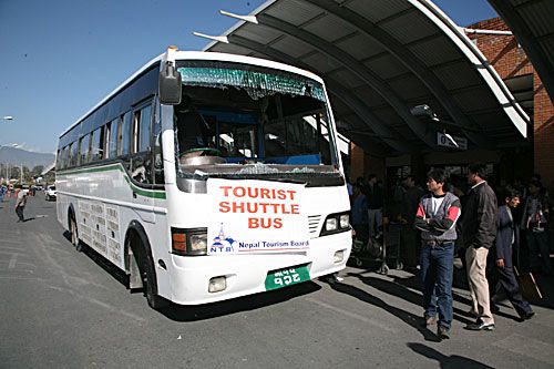 BUMPY WELCOME: A tourist shuttle bus parks outside the Tribhuban International Airport after its windshield was shattered by protestors last Thursday at Tilganga. The capital shut down that day following the murders of two youths, allegedly by the YCL.