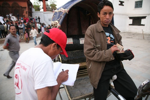 FOR THE CAUSE: A Maoist party worker takes a donation from a riskshaw driver at Hanuman Dhoka on Sunday evening.