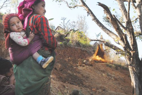 BETTER FUTURE: A woman and her child watch on as a road development project takes place in Rolpa on Sunday.