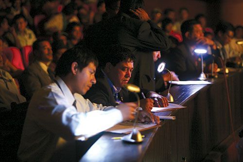 PUMP UP THE POWER: Judges at the body building contest of the Fifth National Games resort to battery-powered lamps during loadshedding on Tuesday.
