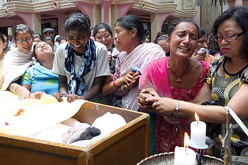 UNITED IN LOSS: Family members mourn the death of Buddha Laxmi Shakya, the third fatality of the blast at the Assumption Church on 23 May. Shakya's daughter Celestina Joseph was also killed in the bombing.