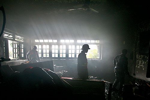 UNHOLY ASH: Firefighters inspect damages after a fire destroyed a building at Tri-Chandra Campus, following a clash between Nepal Student Union and All Nepal National Free Student Union on Monday.