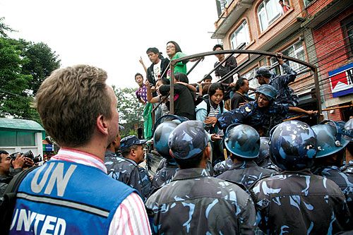 HELPLESS: A UN employee looks on as Tibetan protestors are rounded up after demonstrating for 'Free Tibet' in front of the UN building in Pulchowk last week.