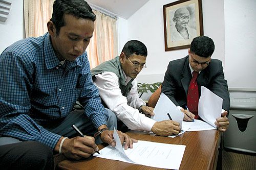 MAHATMA LOOKS ON: The Indian embassy's Counsellor of Economic Cooperation Puneet R Kundal signs a pledge to grant Nepal Rs 25.9 million to build three schools in Doti district.