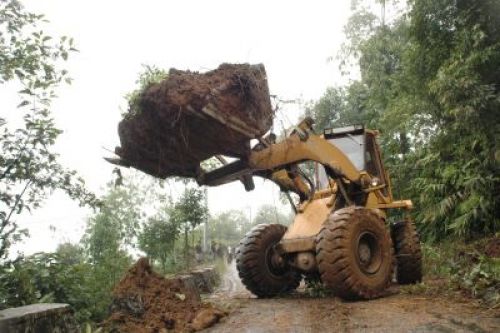 NATURE'S REVOLT: Torrential downpours wreaked havoc on roads and highways across Nepal, forcing road closures and stalling traffic. A dozer picks up packs of mud from a landslide along the Mechi highway connecting Birtamot and Ilam on Friday following heavy rains.