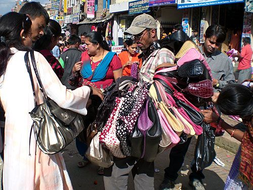 BAGMAN: An overburdened salesman sells a bag to customers in Patan last week.