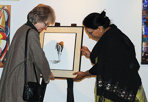 TRIBUTE: Wilda Campbell hands over an oil painting entitled 'Fruit Seller' by the late Rama Nanda Joshi to his wife Nirmala Joshi. The painting will be exhibited at the R.N. Joshi Museum.