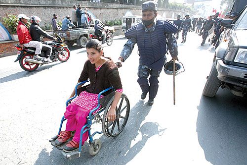 HELPING HAND: Policeman Bipendra Thakur helps Saraswati Timilsina through traffic in Tripureshwor during the International Day of Disabled Persons on Thursday.