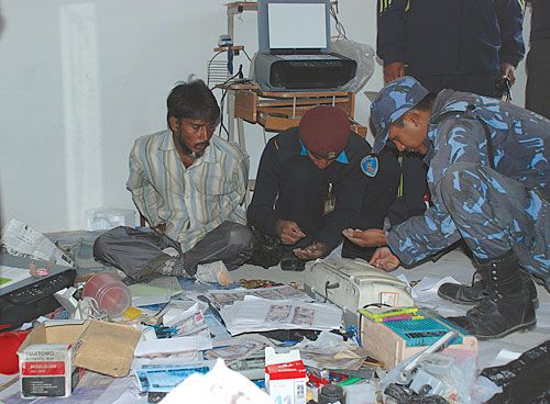 NOT SO FAST: Policemen recover around Rs 300,000 and IC 5000 worth of counterfeit money as the perpetrator, Jagir Sikh Adit, looks on in Lalitpur on Thursday.