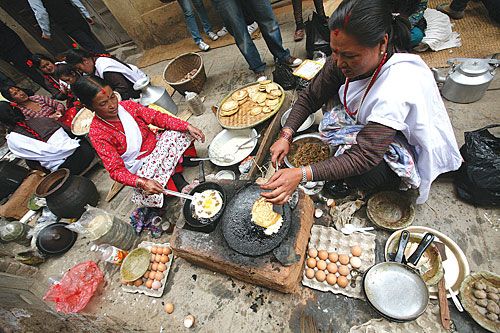 FIESTA: Newari women make lentil pancakes for a food festival in Kirtipur on Sunday.