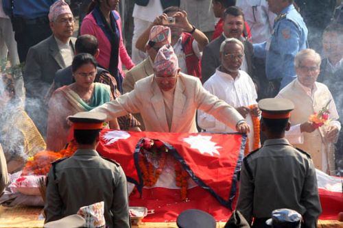 THE LAST AUDIENCE: Prime Minister Madhav Kumar Nepal lays Nepali national flag on the body of former Prime Minister and Nepali Congress President Girija Prasad Koirala