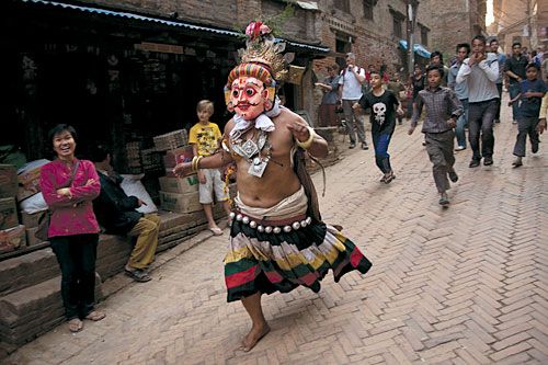 TAG, YOU'RE IT: A man dressed as Kal Bhairab plays tag with children in Bhaktapur on Sunday.