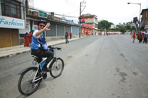 MONITORING RIGHTS: OHCHR Country Chief Richard Bennett waves from his bicycle on his way to monitor rallies.