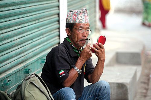 LOOKING GOOD: An out-of-town Maoist supporter takes some time off for personal grooming on Monday.